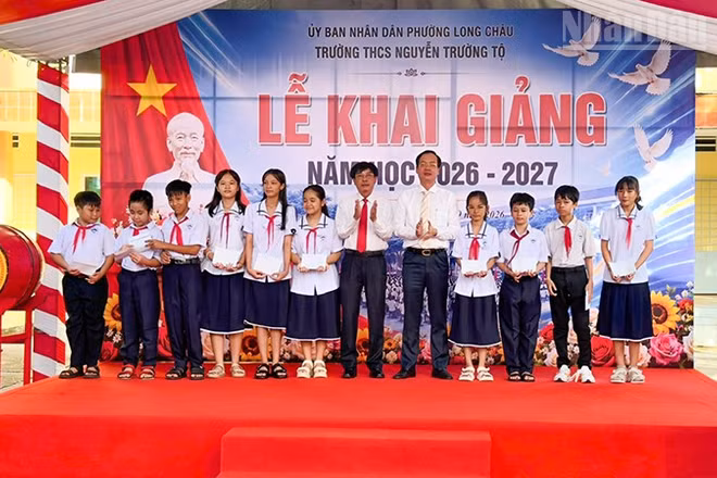 Chủ tịch Ủy ban nhân dân tỉnh Vĩnh Long Trần Trí Quang trao học bổng cho học sinh Trường trung học cơ sở Nguyễn Trường Tộ. (Ảnh: BÁ DŨNG)