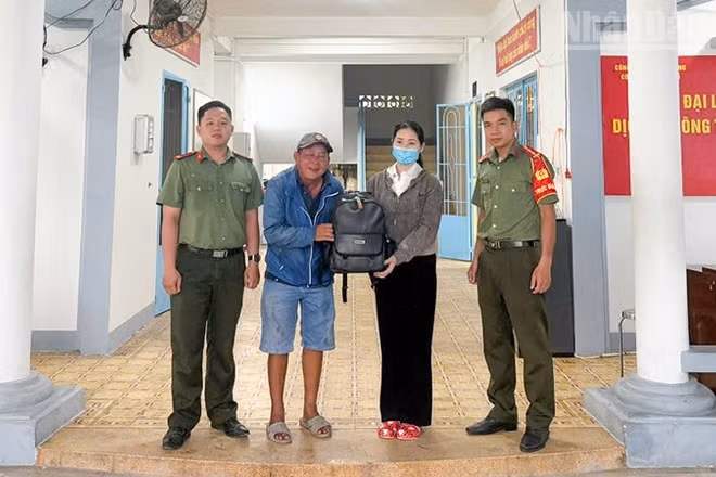 Công an Long Hồ hỗ trợ người dân nhận lại tài sản. (Ảnh: CA cung cấp)