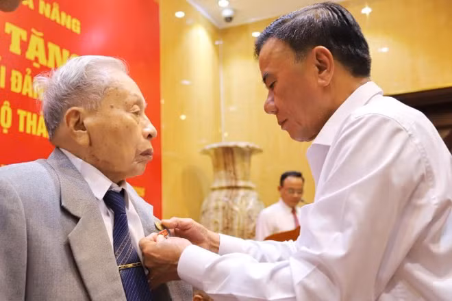 Đồng chí Trần Cẩm Tú, Ủy viên Bộ Chính trị, Thường trực Ban Bí thư trao Huy hiệu 80 năm tuổi Đảng cho đảng viên lão thành Trần Thanh Dân. 