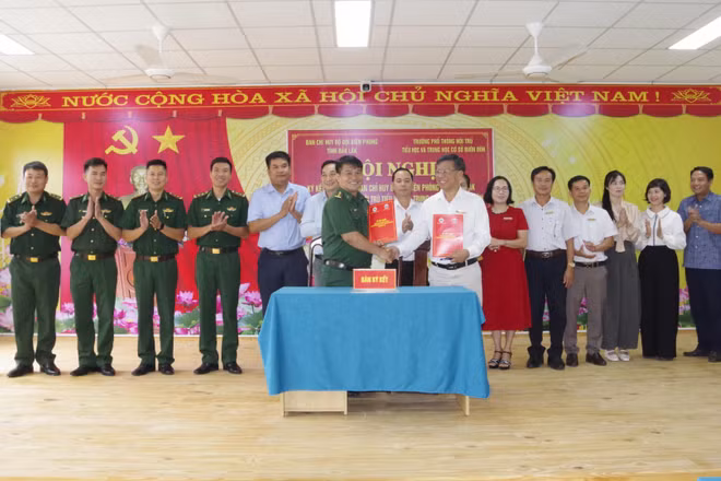 Lãnh đạo Ban Chỉ huy Bộ đội Biên phòng tỉnh Đắk Lắk và Trường phổ thông nội trú tiểu học và trung học cơ sở Buôn Đôn trao biên bản ký kết kết nghĩa. (Ảnh: DÂN QUÂN)