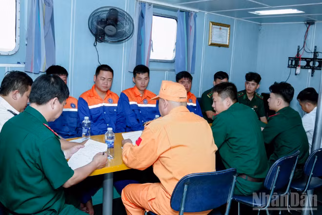 Đại diện Tàu SAR 413 và Bộ đội Biên phòng thành phố Cần Thơ đang làm các thủ tục bàn giao 4 thuyền viên.