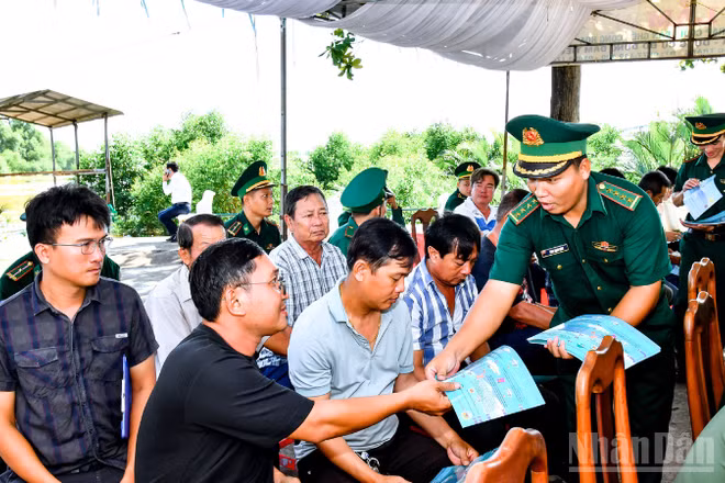 Cán Bộ đồn Biên phòng Trung Bình cấp phát tờ rơi tuyên truyền chống khai thác IUU cho bà con ngư dân tham dự lễ ra quân.