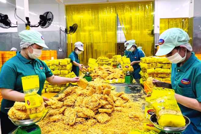 Công nhân Công ty cổ phần Lương thực thực phẩm SAFOCO làm việc trong một dây chuyền sản xuất. (Ảnh CTV)