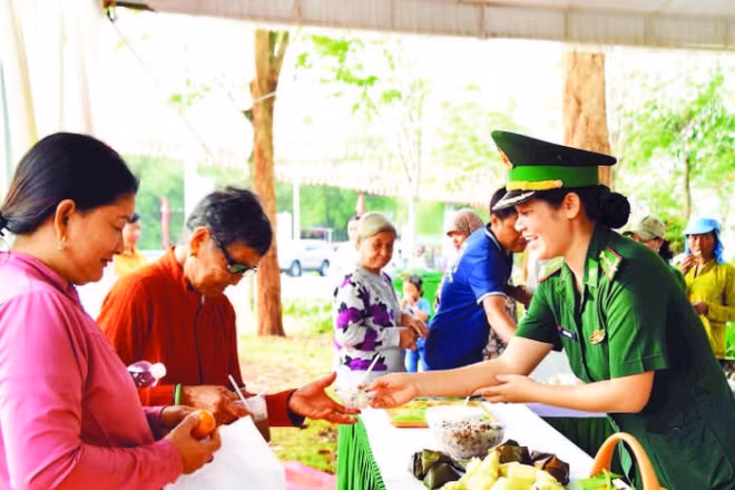 Cán bộ Đồn Biên phòng quốc tế Hoa Lư trao các suất ăn 0 đồng cho nhân dân xã Lộc Thạnh tham gia “Ngày hội Biên phòng toàn dân” được tổ chức ngày 3/3 vừa qua.