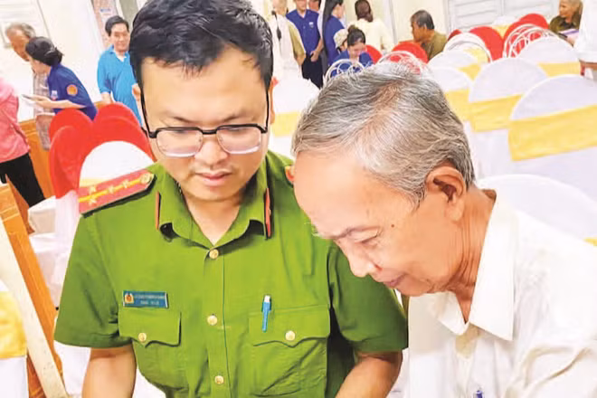 Cán bộ Công an phường Thuận Hóa hỗ trợ người cao tuổi bỏ phiếu bầu tổ trưởng qua ứng dụng trên điện thoại (Ảnh PHƯỜNG THUẬN HÓA)