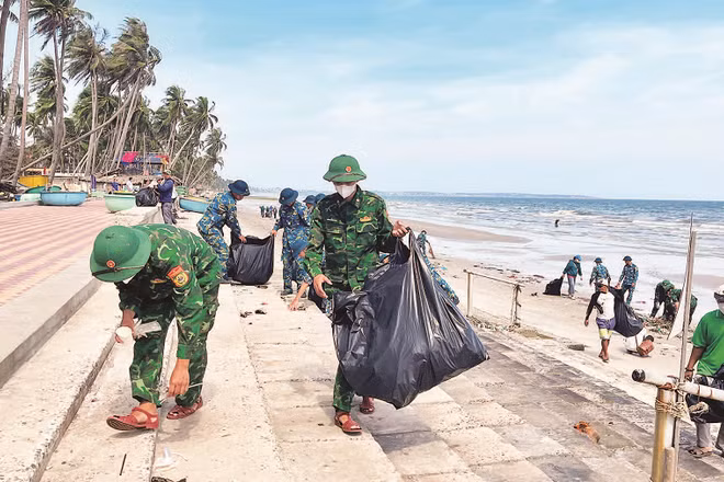 Các lực lượng đoàn thể cùng với người dân tham gia nhặt rác bãi biển bảo vệ môi trường tại phường Mũi Né.
