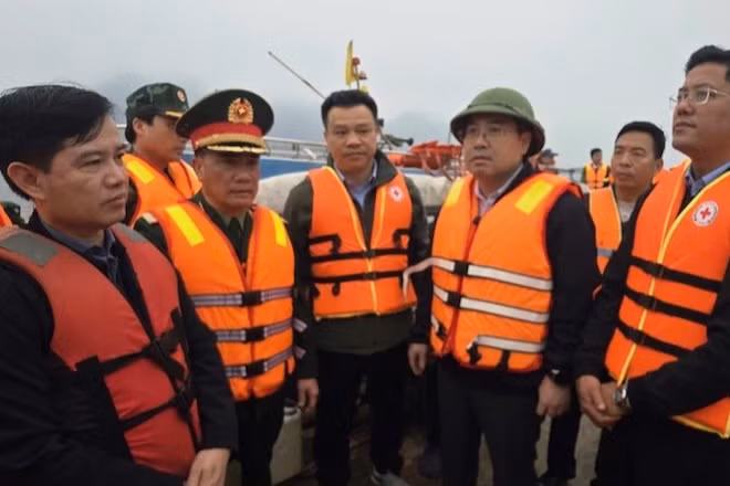 Chủ tịch Ủy ban nhân dân tỉnh Lào Cai Nguyễn Tuấn Anh (người đội mũ, thứ ba từ phải sang) trực tiếp có mặt tại hiện trường, chỉ đạo công tác cứu hộ các nạn nhân bị chìm tàu trên hồ Thác Bà tối 21/2.