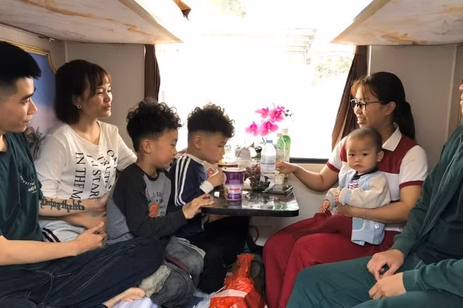 Gia đình chị Nguyễn Minh Thu, Nguyễn Thu Trang quây quần trong khoang tàu.