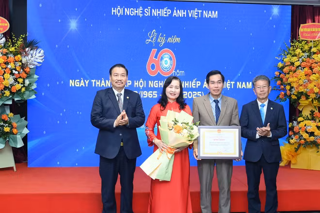 Ông Đoàn Thành Nô, Phó Bí thư phụ trách Đảng ủy, Phó Chủ tịch Thường trực Liên hiệp các Hội Văn học Nghệ thuật Việt Nam trao bằng khen tặng Hội Nghệ sĩ Nhiếp ảnh Việt Nam.
