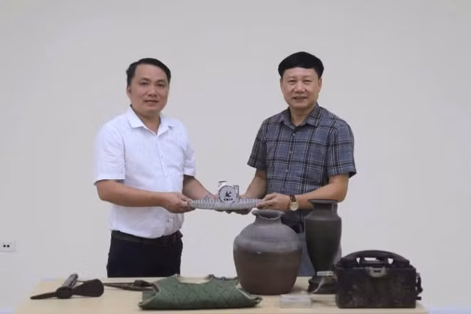Phó Giám đốc Bảo tàng tỉnh Quảng Trị Mai Thế Trung (áo trắng) trao hiện vật, tư liệu phục vụ xây dựng Bảo tàng Đảng Cộng sản Việt Nam 