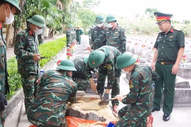 Lực lượng chức năng thực hiện lấy mẫu tại nghĩa trang Ba Dốc, tỉnh Quảng Trị. (Ảnh: QS)