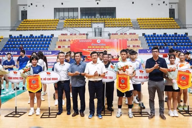 Các đại biểu tặng cờ lưu niệm và hoa cho đại diện các đoàn vận động viên (Ảnh: HG)