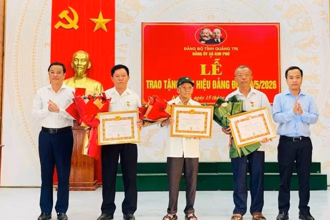 Thường trực Đảng ủy xã Kim Phú, tỉnh Quảng Trị trao Huy hiệu Đảng và tặng hoa chúc mừng các đảng viên.
