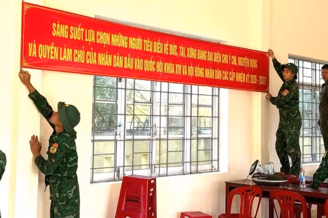 Cán bộ, chiến sĩ Đồn Biên phòng Xuân Hòa treo băng rôn tuyên truyền, hoàn thiện công tác trang trí tại khu vực bỏ phiếu trên địa bàn xã Xuân Cảnh.