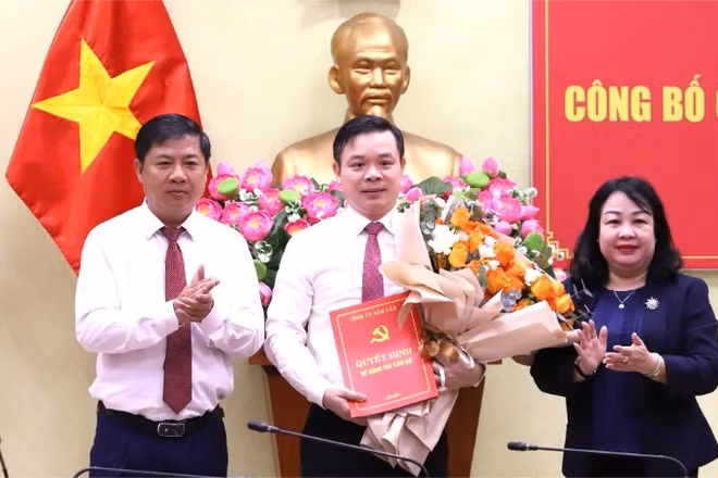 Các đồng chí Ủy viên Trung ương Đảng: Lương Nguyễn Minh Triết, Bí thư Tỉnh ủy và Cao Thị Hòa An, Phó Bí thư Thường trực Tỉnh ủy, Chủ tịch Hội đồng nhân dân tỉnh Đắk Lắk trao Quyết định của Ban Thường vụ Tỉnh ủy và tặng hoa chúc mừng đồng chí Đỗ Hữu Huy. (Ảnh: TRUNG TÂN)
