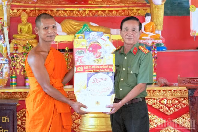 Đại tá Phạm Minh Lũy, Phó Giám đốc Công an tỉnh Cà Mau (bìa phải) trao tặng quà Tết tại chùa Cao Dân, xã Tân Lộc, tỉnh Cà Mau.