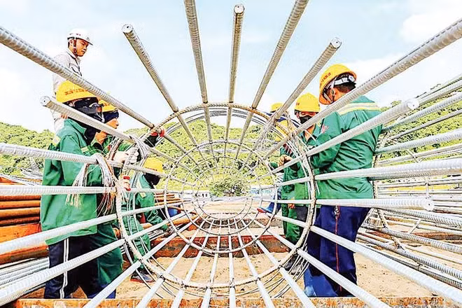 Kỹ sư và công nhân gia công lồng thép cọc khoan nhồi trên bãi đúc.