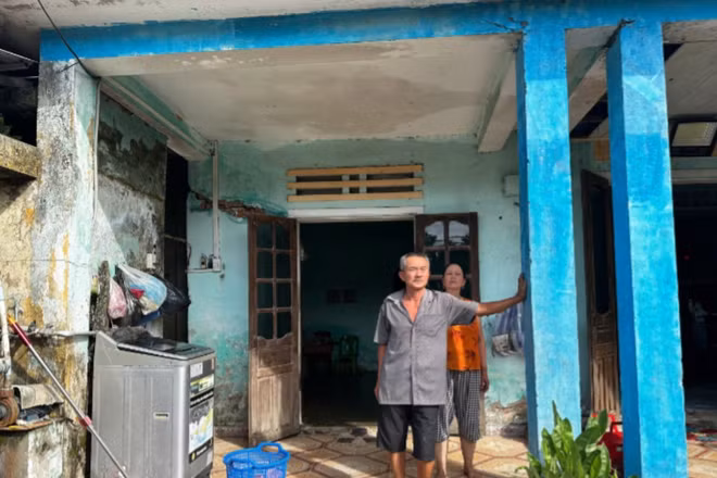 Vợ chồng ông Nguyễn Lê thất thần trước ngôi nhà có thể sập bất cứ lúc nào. (Ảnh: ANH ĐÀO)