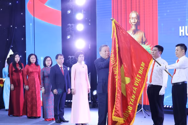 Tổng Bí thư Tô Lâm gắn Huân chương Hồ Chí Minh lên lá cờ truyền thống Thông tấn xã Việt Nam. Ảnh: Lâm Khánh - TTXVN