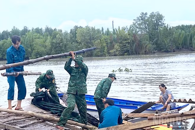 Cán bộ, chiến sĩ Đồn Biên phòng Đất Mũi cùng các lực lượng có liên quan tại địa phương giúp dân khắc phục hậu quả vì sạt lở đất.