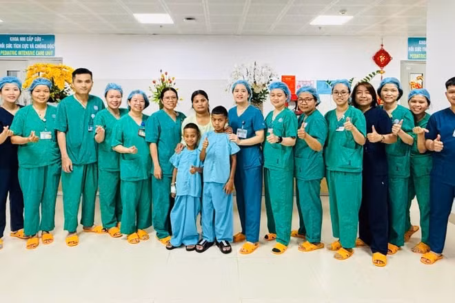 Hai bệnh nhi và ê-kíp các y bác sĩ Bệnh viện Phụ sản-Nhi Đà Nẵng.