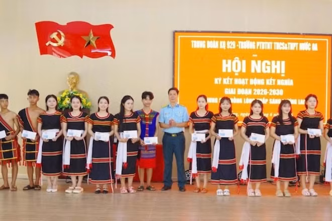 Thượng tá Nguyễn Mạnh Quyền, Chủ nhiệm chính trị Sư đoàn 372 trao quà tặng các em học sinh Trường Phổ thông dân tộc nội trú Trung học cơ sở và Trung học phổ thông Nước Oa.