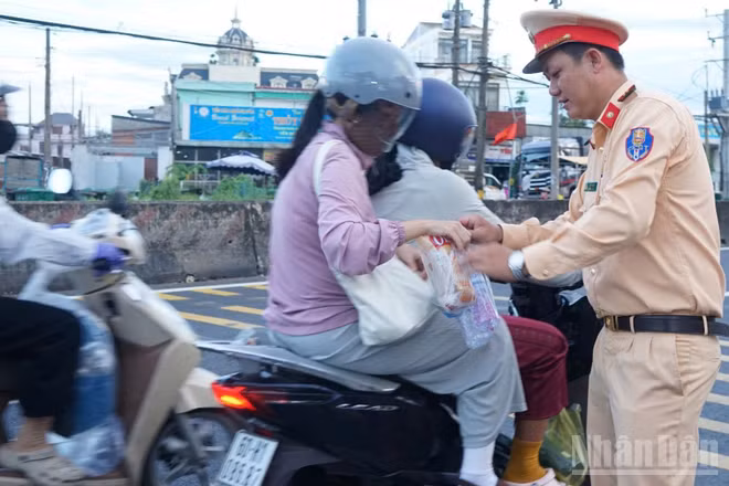 Lực lượng Cảnh sát giao thông (Công an tỉnh Đồng Tháp) tặng quà cho người dân về quê nghỉ lễ.
