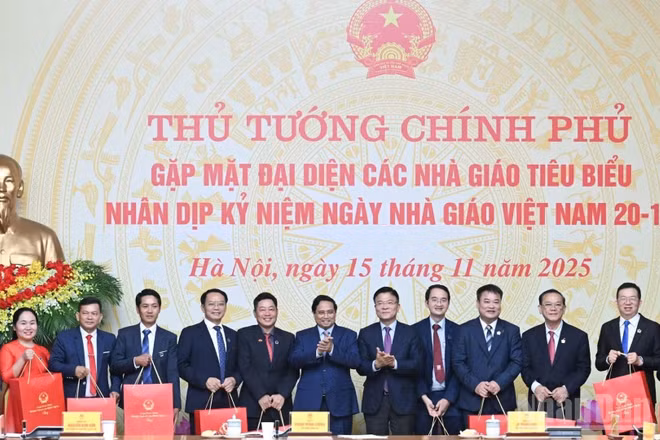 Thủ tướng Chính phủ Phạm Minh Chính tặng quà chúc mừng các giáo viên tiêu biểu tại buổi gặp mặt. (Ảnh: TRẦN HẢI)