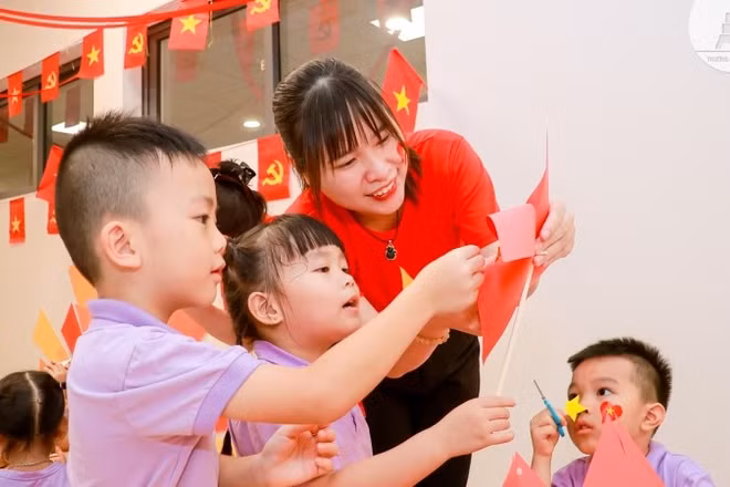 Cô và trò cùng nhau làm lá cờ đỏ sao vàng.