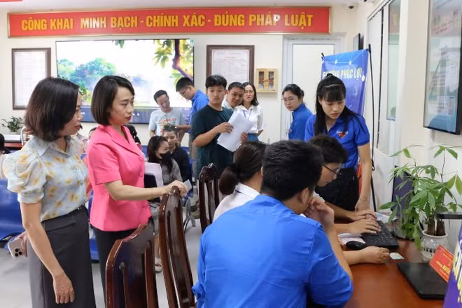 Cán bộ phường Phúc Lợi hỗ trợ người dân thực hiện thủ tục hành chính.