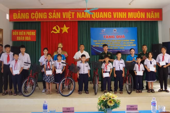 Đại diện Đồn Biên phòng Xuân Hòa phối hợp với Ủy ban Mặt trận Tổ quốc Việt Nam xã Xuân Cảnh trao quà cho các em học sinh.