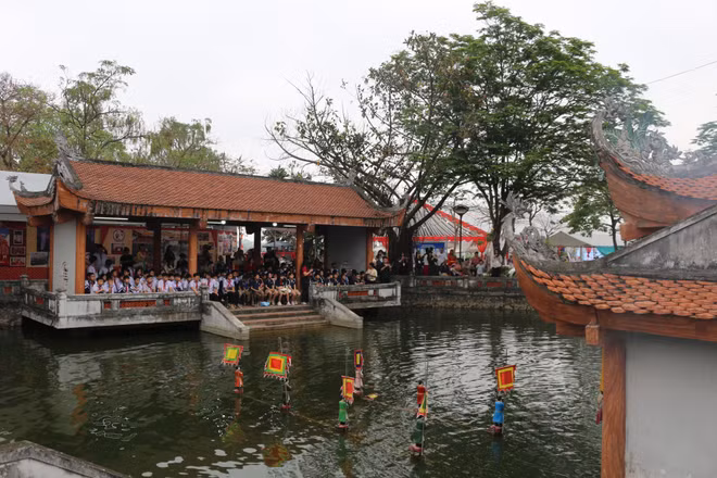 Ao làng rộn rã tiếng cười khi các em học sinh xem biểu diễn rối nước.