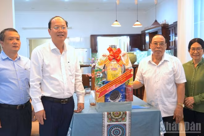 Bí thư Tỉnh ủy Nguyễn Hồ Hải (thứ hai, từ trái qua) trao tặng quà cho gia đình đồng chí Phạm Thanh Trị.