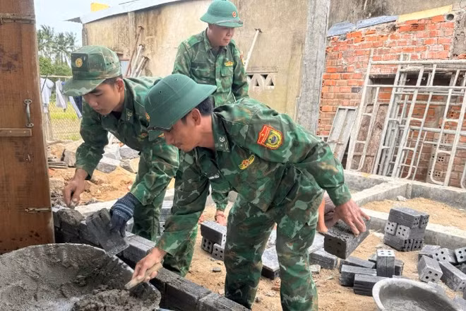 Thiếu tá Nguyễn Thanh Diễn cùng đồng đội trực tiếp xây tường, dựng lại mái ấm cho gia đình anh Trần Thế Lâm bị thiệt hại do mưa lũ.