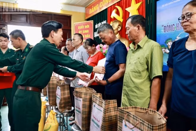 Thượng tá Nguyễn Văn Lập, Chủ nhiệm chính trị Bộ đội Biên phòng thành phố Hải Phòng trao quà và tặng cờ Tổ quốc cho các hộ dân trên đảo.