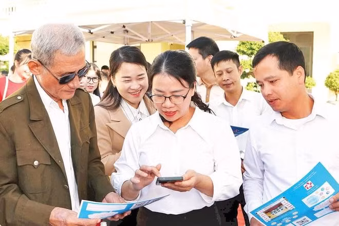 Cán bộ phường An Phong hướng dẫn người dân lấy số thứ tự giải quyết thủ tục hành chính trên VNeID.