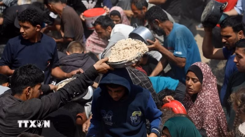 Người dân nhận thực phẩm cứu trợ tại Gaza. (Ảnh: THX/TTXVN)