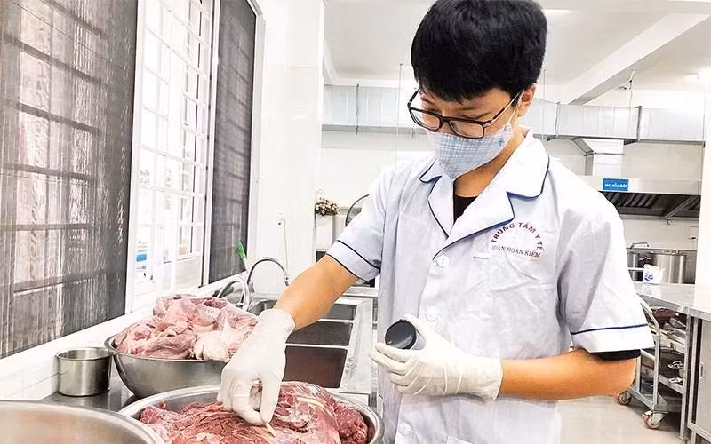 Kiểm tra (test) thực phẩm trước khi chế biến tại bếp ăn trường học. (Ảnh: BÁO NHÂN DÂN)