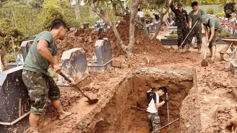 Các lực lượng thực hiện khai quật, lấy mẫu hài cốt liệt sĩ tại Nghĩa trang liệt sĩ Nhổn, phường Tây Tựu, Hà Nội. (Ảnh: MAI HOA)
