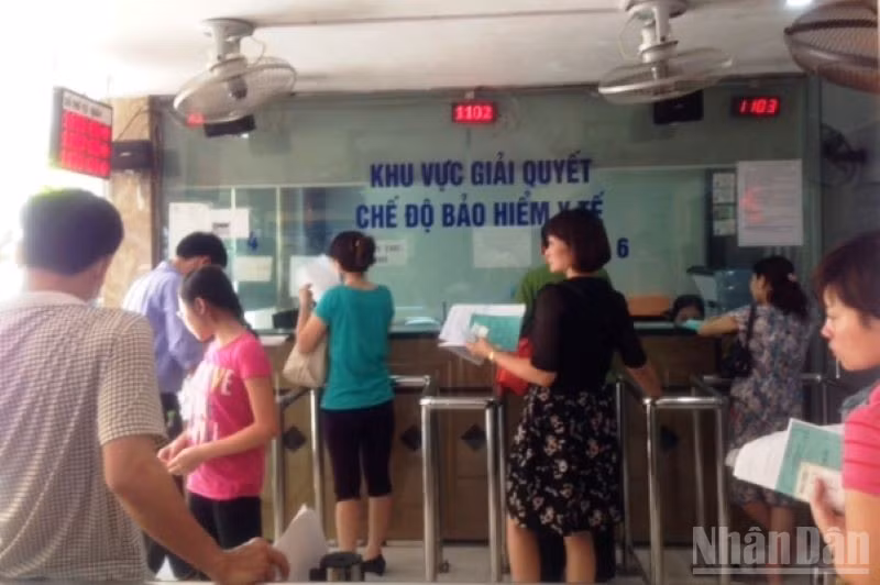 Người dân làm thủ tục đăng ký khám bệnh, chữa bệnh bảo hiểm y tế tại Bệnh viện. (Ảnh: ĐỖ THOA)