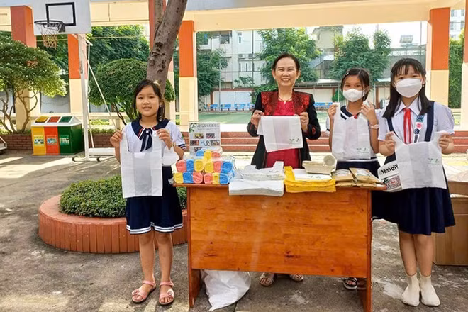 Chị Phan Thị Thúy Phượng (giữa) giới thiệu và tuyên truyền với học sinh về những lợi ích của túi ni-lông sinh học tự hủy. (Ảnh: nhân vật cung cấp)