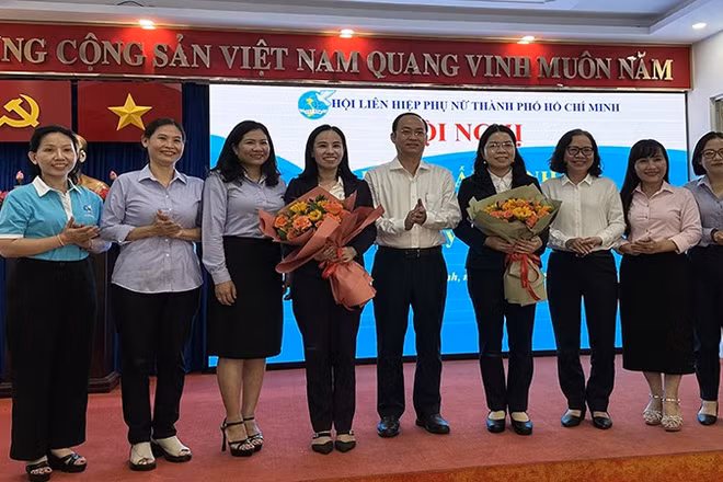 Đại diện Thành ủy và Ủy ban nhân dân thành phố tặng hoa chúc mừng bà Nguyễn Thị Ngọc Xuân (thứ tư từ phải sang).