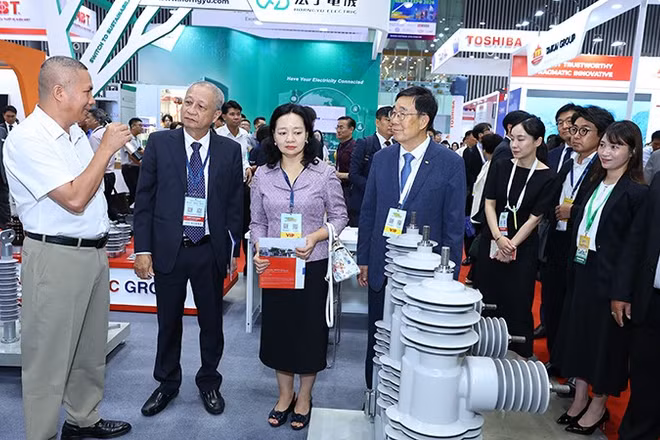 Các đại biểu và khách tham quan một gian hàng tại triển lãm.