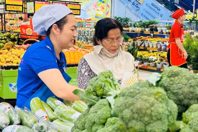 Người dân mua rau xanh bình ổn thị trường trong một siêu thị Co.opmart ở Thành phố.