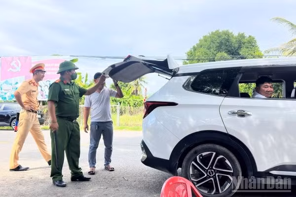 Lực lượng chức năng kiểm tra phương tiện ra vào xã Diên Lâm tại chốt cầu Phú Cốc. (Ảnh: VŨ TÂN)