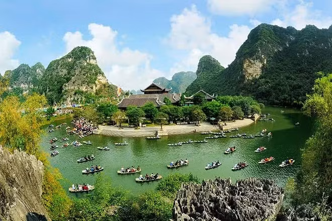 Du khách tham quan Di sản Văn hóa và Thiên nhiên thế giới Tràng An. (Ảnh: NINH MẠNH THẮNG)