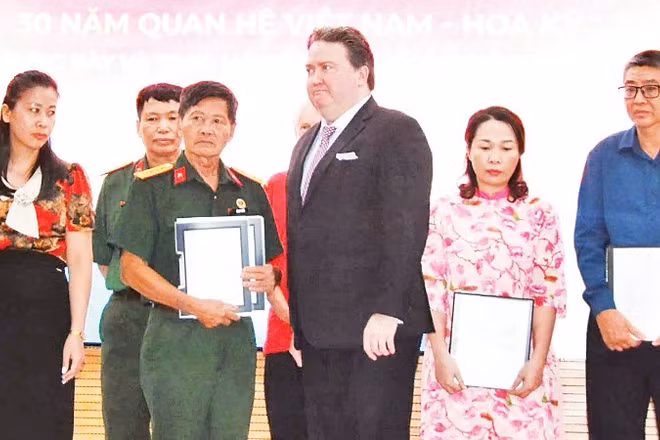 Cựu Đại sứ Hoa Kỳ tại Việt Nam Marc Knapper trao trả hồ sơ thời chiến cho đại diện Ban liên lạc Đoàn công tác chính sách quy tập hài cốt liệt sĩ Sư đoàn 308 và các thân nhân liệt sĩ.