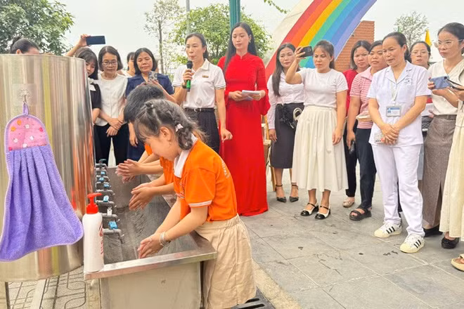 Cán bộ Trạm Y tế phường Tây Tựu hướng dẫn các em học sinh trên địa bàn rửa tay bằng xà phòng đúng cách để phòng bệnh tay chân miệng.