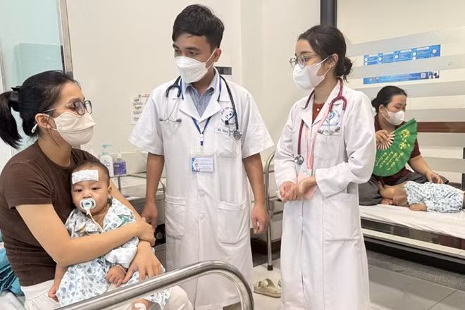 Các y, bác sĩ Bệnh viện Nhi Hà Nội chăm sóc trẻ bị bệnh tay chân miệng trên địa bàn Hà Nội. (Ảnh: VÂN VÂN) 