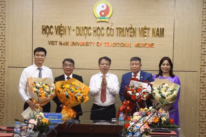 Phó Giáo sư, Tiến sĩ Nguyễn Quốc Huy, Giám đốc Học viện Y-Dược học cổ truyền Việt Nam trao Quyết định và tặng hoa cho các Phó Giáo sư tại buổi lễ.